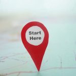 Red locator symbol with Start Here text on a map
