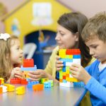 Kids playing with plastic building blocks at kindergarten