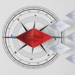 Concept vision leadership temwork and workforce leader management with red paper ship on compass needle pointing in front of leading among paper ship white.
