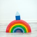 A wooden rainbow with a cubbyhole on it