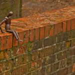A mannequin person stands precariously on the edge of a bridge edge with bad thoughts. The possibility of committing suicide.