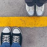 Sneakers from above. Male and female feet in sneakers from above, standing at dividing line.